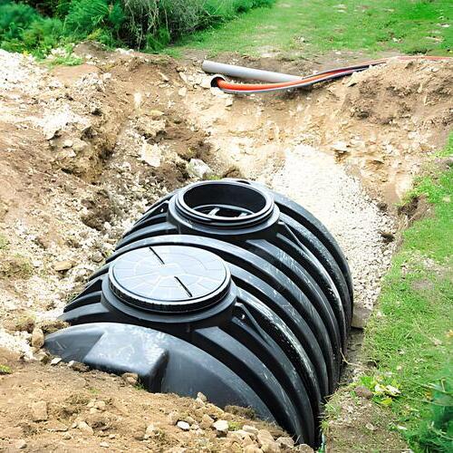 septic tank being lowered into the ground